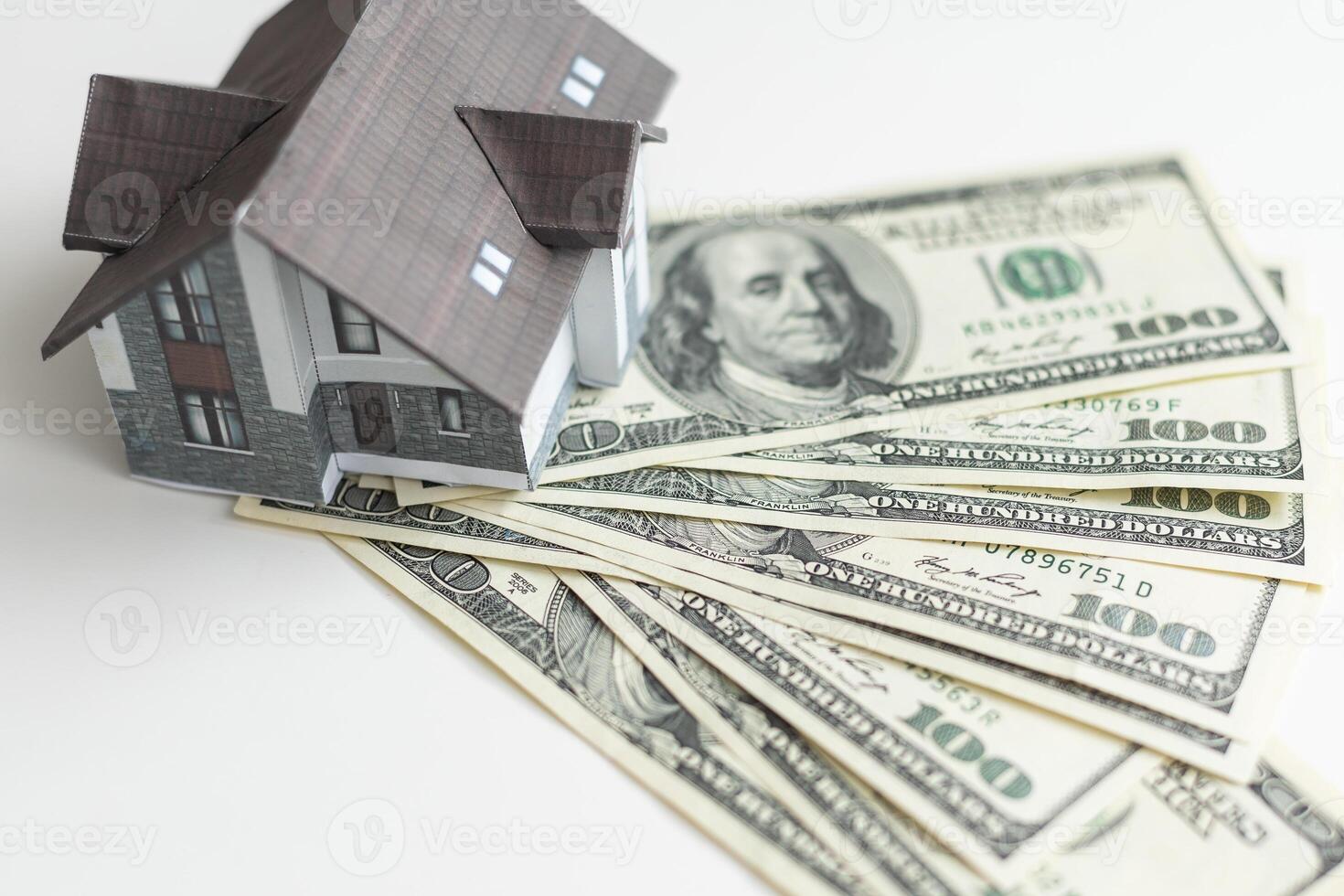 A toy house made of wood with a roof costs money, on a hundred-dollar bill. Concept. mortgage, purchase, sale of real estate, rental housing. photo