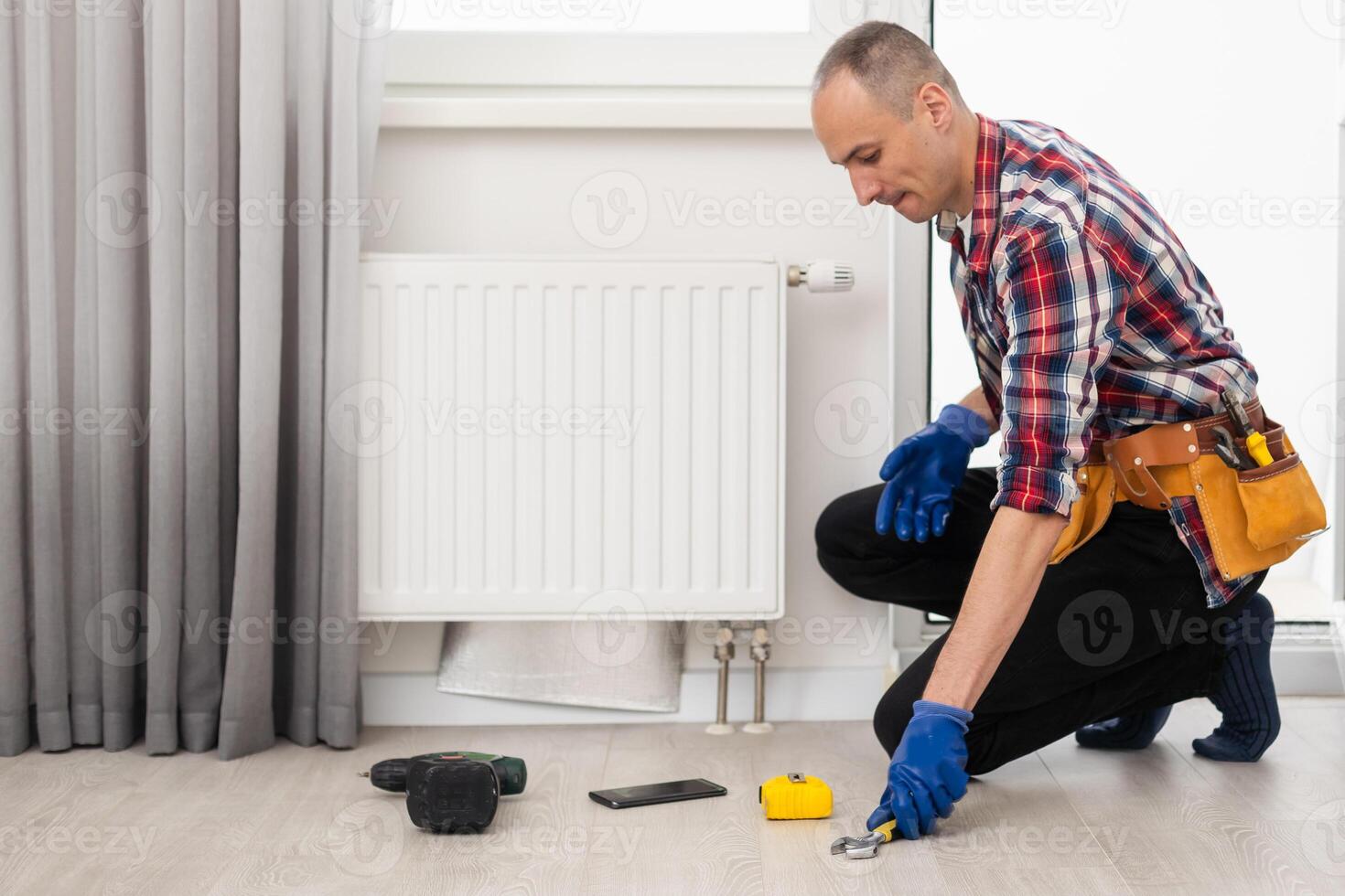 Central heating mechanic and handyman fixing home radiator, gas crisis and seasonal issues. photo