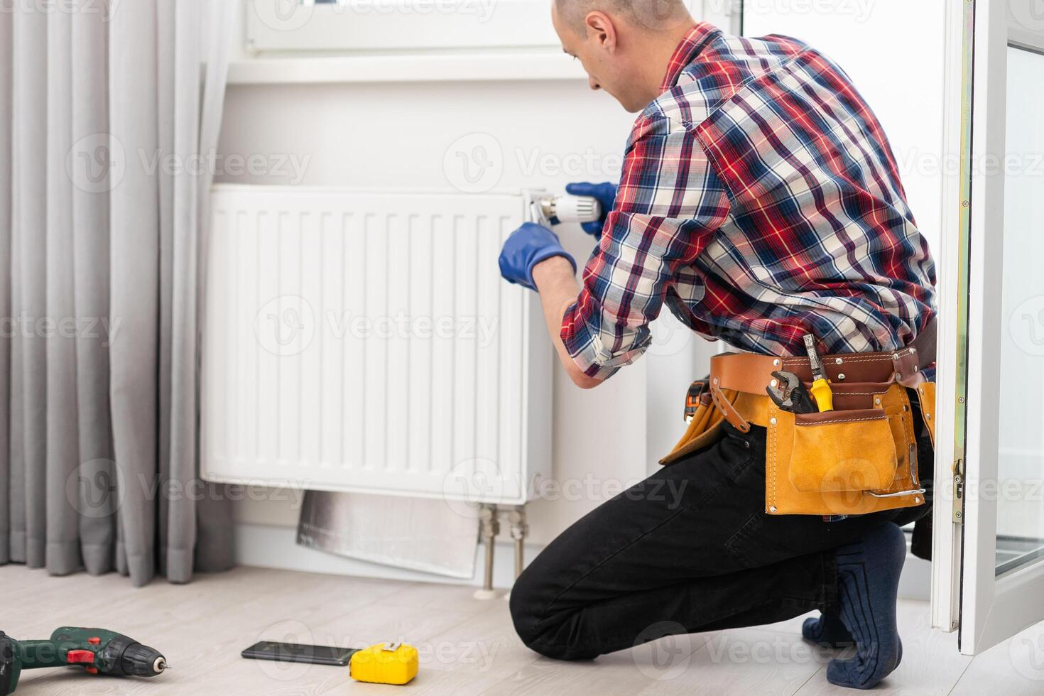 man repairing radiator with wrench. Removing air from the radiator photo