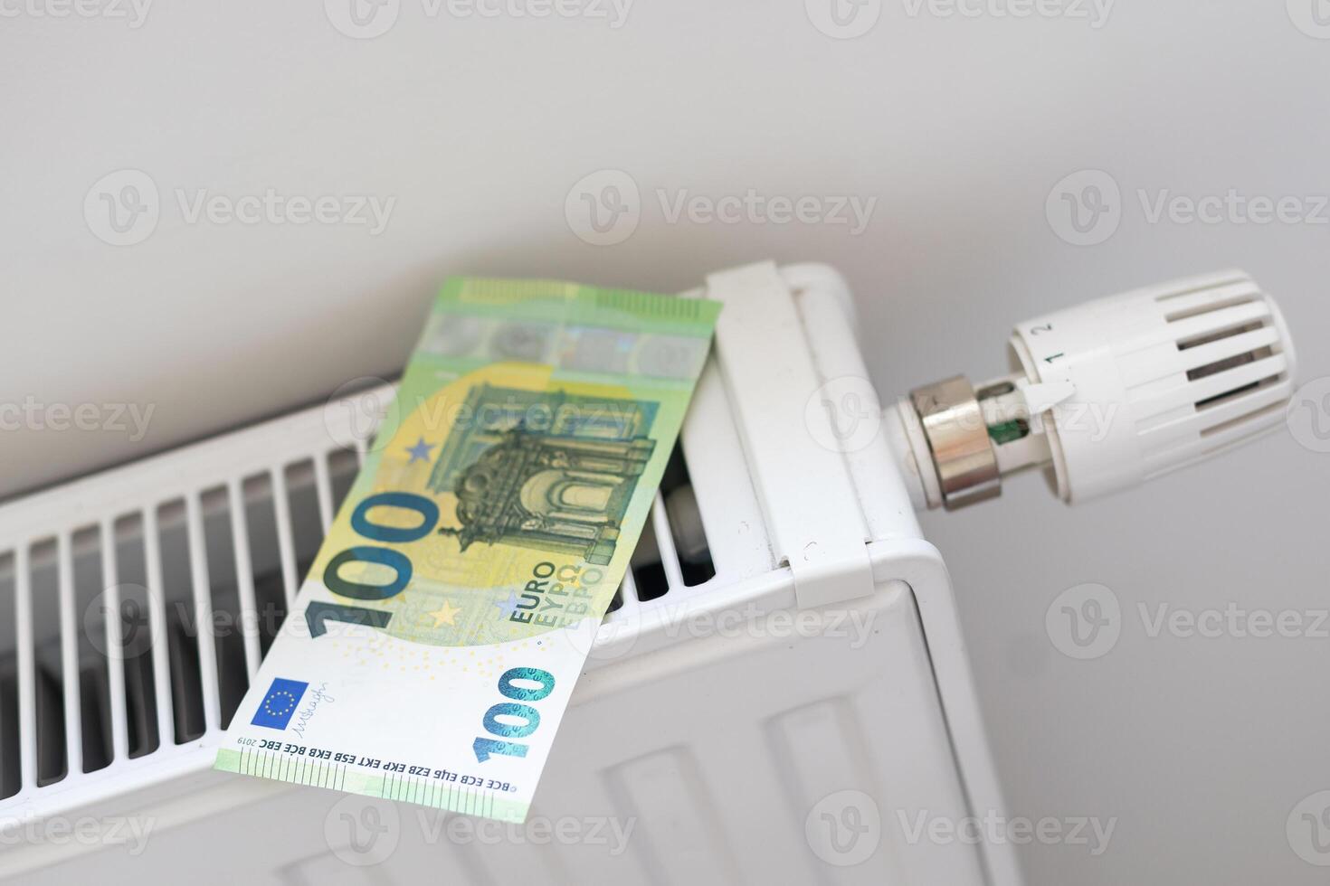 Calculator and fifty euro banknotes lie on the radiator of the heating system, the cost of heat, utility bills photo