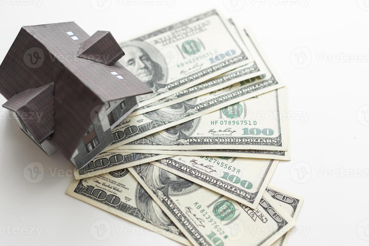 A toy house made of wood with a roof costs money, on a hundred-dollar bill. Concept. mortgage, purchase, sale of real estate, rental housing. photo