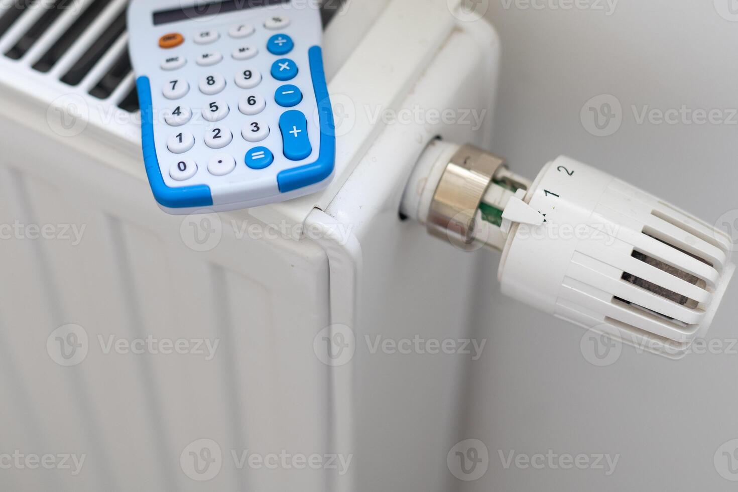 The concept of the high cost of heating and electricity in Europe in 2023. The prospect of rising heating costs. A pack of 100 euro banknotes lies on a heating radiator with a thermostat photo