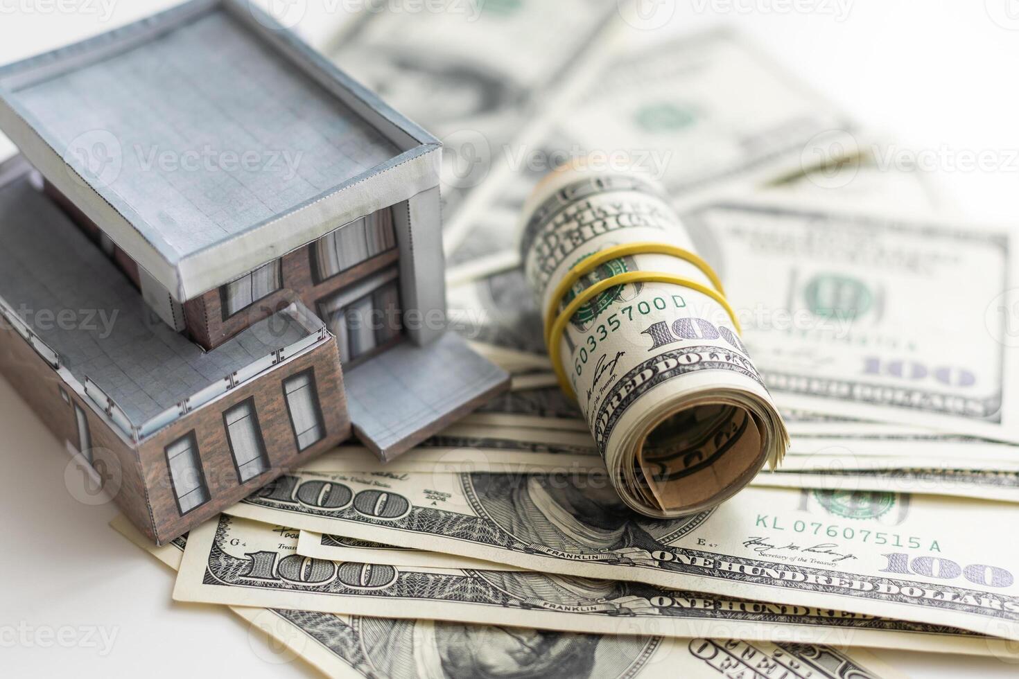 A toy house made of wood with a roof costs money, on a hundred-dollar bill. Concept. mortgage, purchase, sale of real estate, rental housing. photo