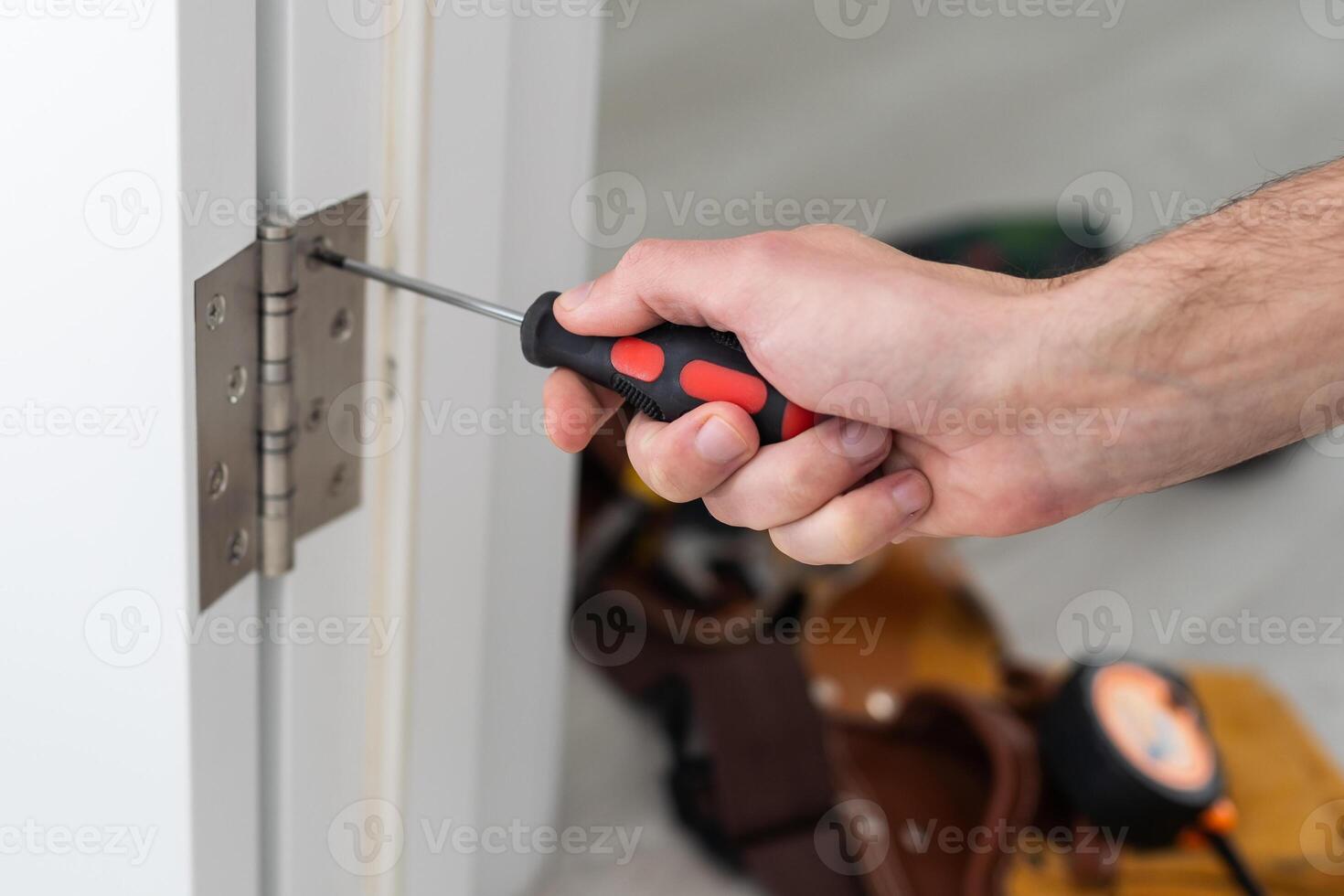 A handyman repair the door lock in the room. The concept repair yourself. Selective focus photo