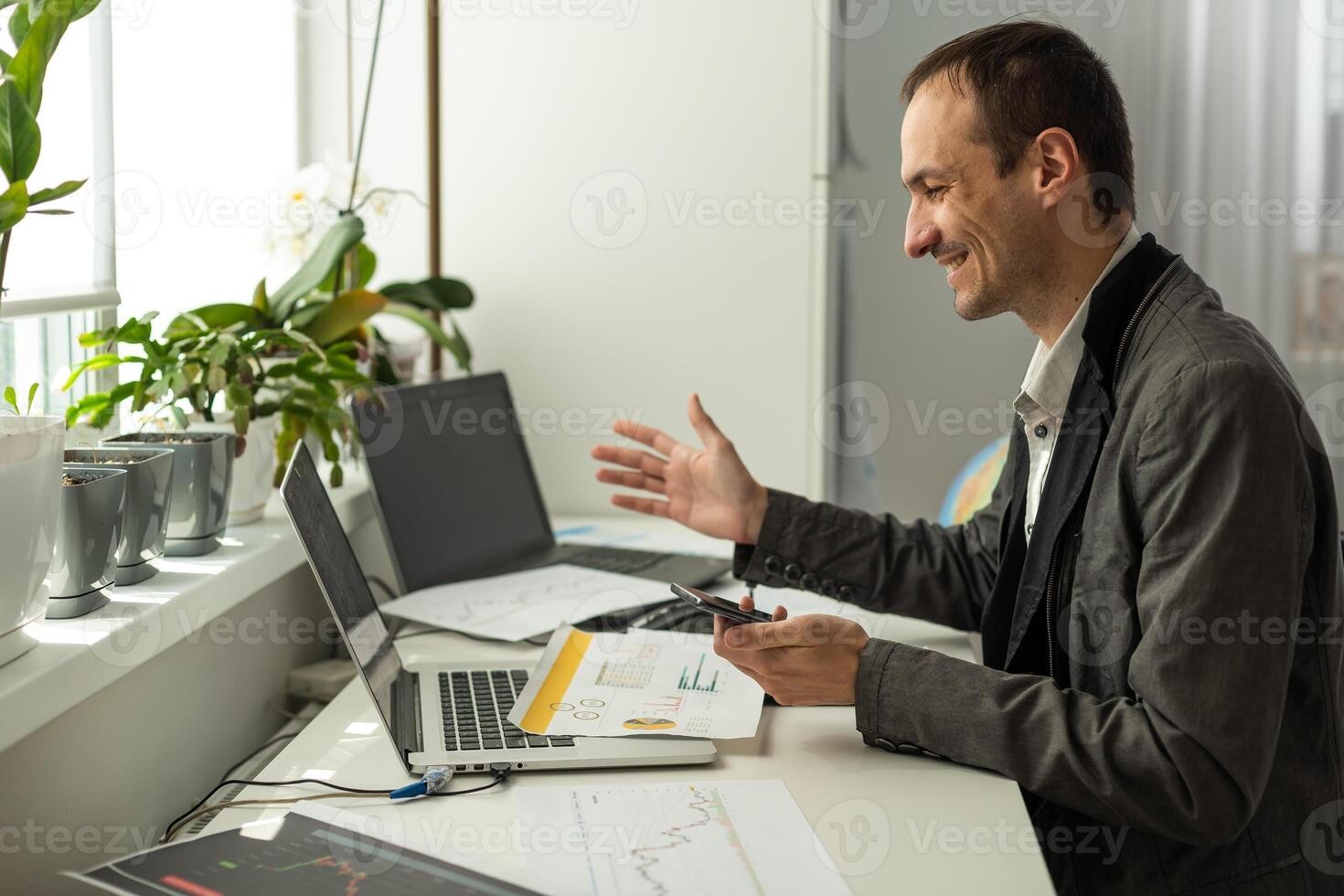 Happy joyful successful caucasian male stock investor, broker, sit at his work desk, looks at computer, rejoices in the growth of stock shares, photo