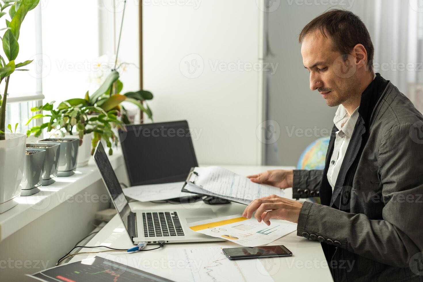 Thoughtful focused successful caucasian male stock investor, broker, financial adviser, sits at work desk, looks at computer photo