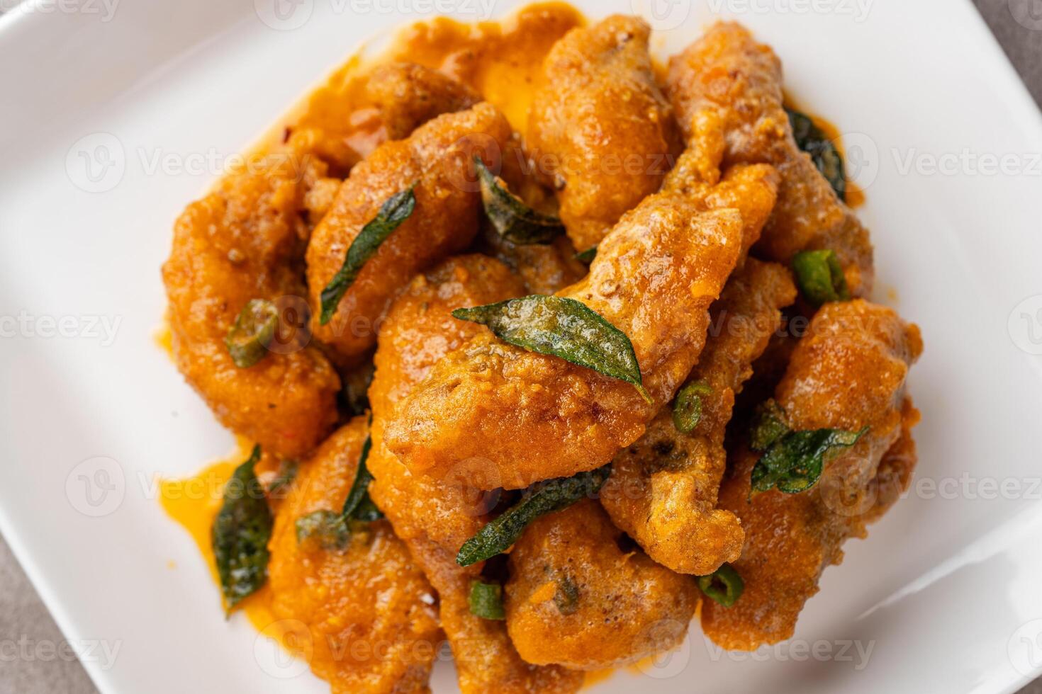Crispy fried dori fish coated with salted egg plated on a white plate photo