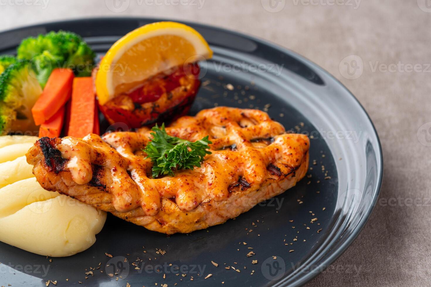Grilled salmon fillets with mentai sauce and mash potato plating on black plate with negative space for text. photo