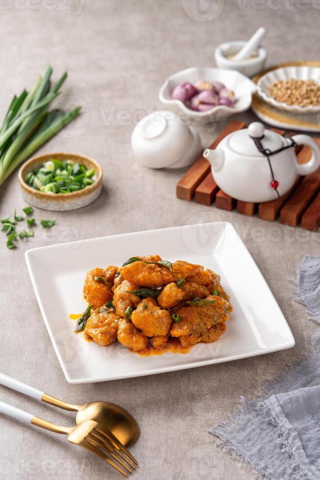 Crispy fried dori fish coated with salted egg plated on a white plate photo