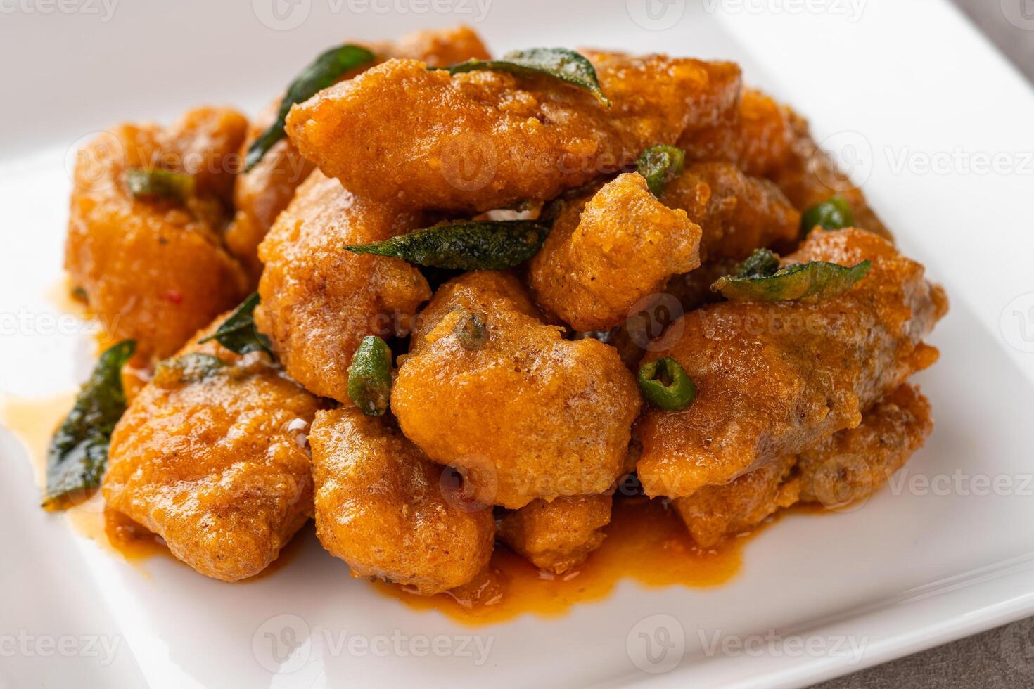 Crispy fried dori fish coated with salted egg plated on a white plate photo