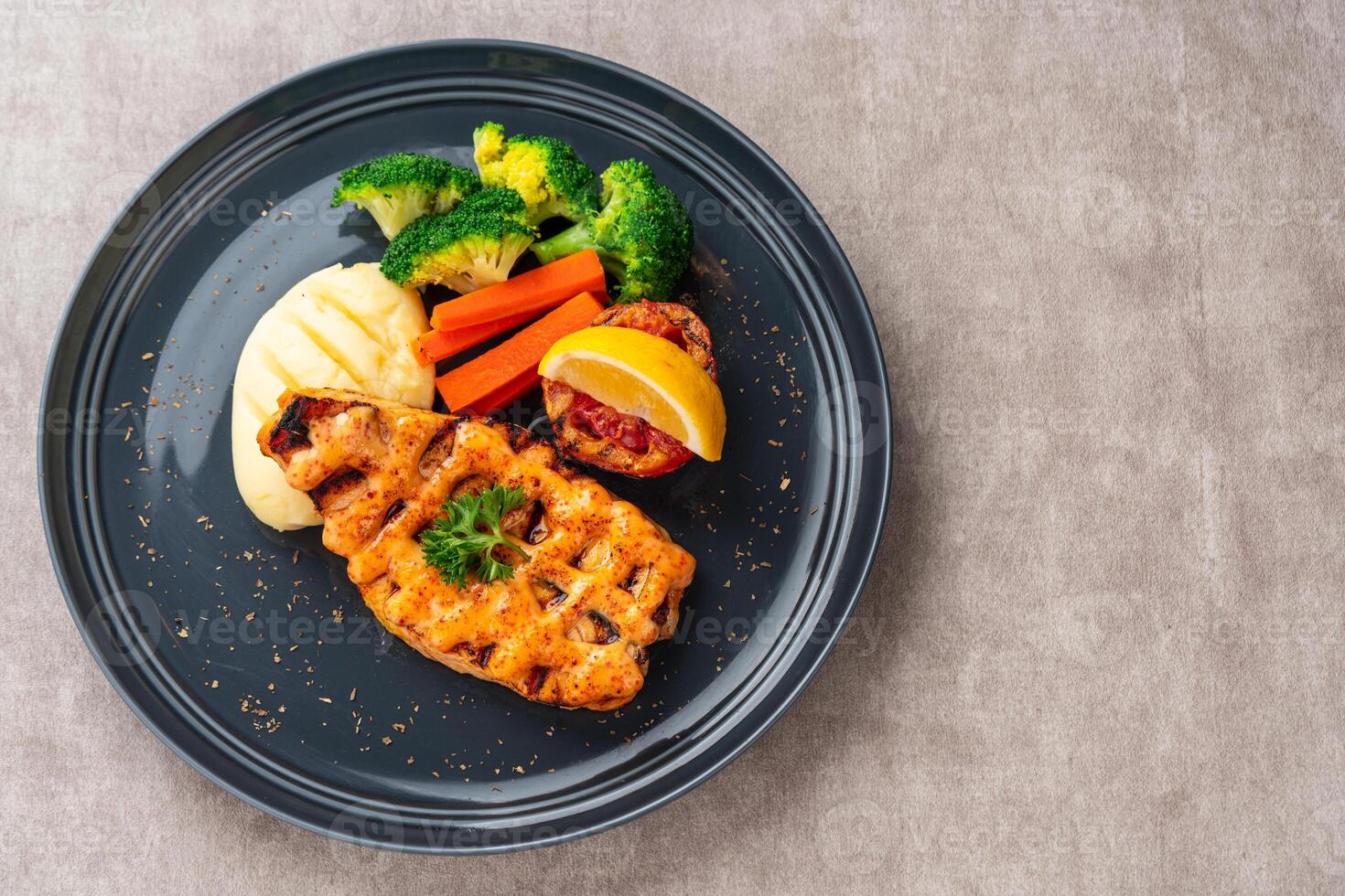 Grilled salmon fillets with mentai sauce and mash potato plating on black plate with negative space for text. photo