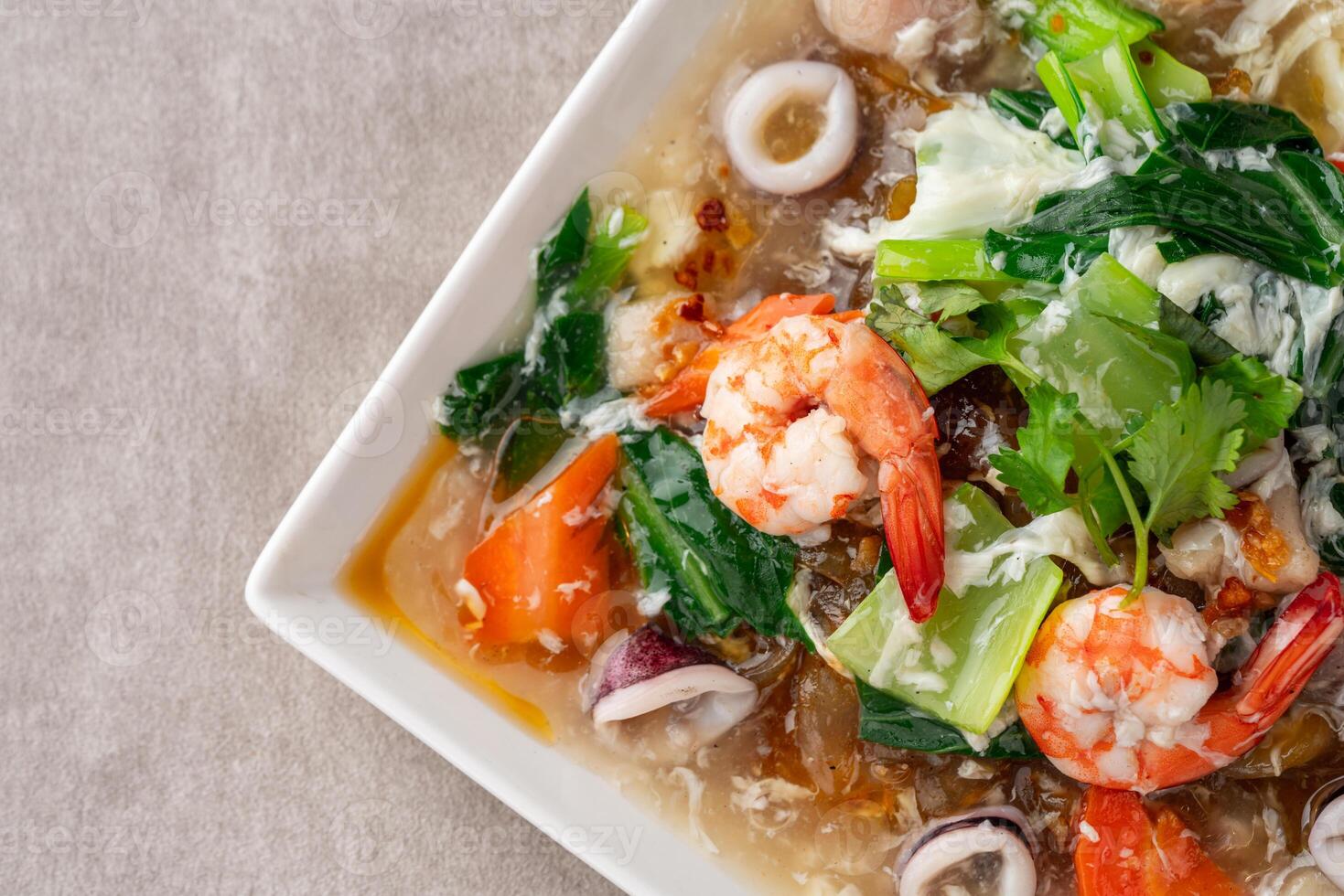 kwetiau siram is Chinese cuisine which is popular in Indonesia, cooked by frying added with complementary vegetables and chicken, seafood or beef meat and thick soup. photo
