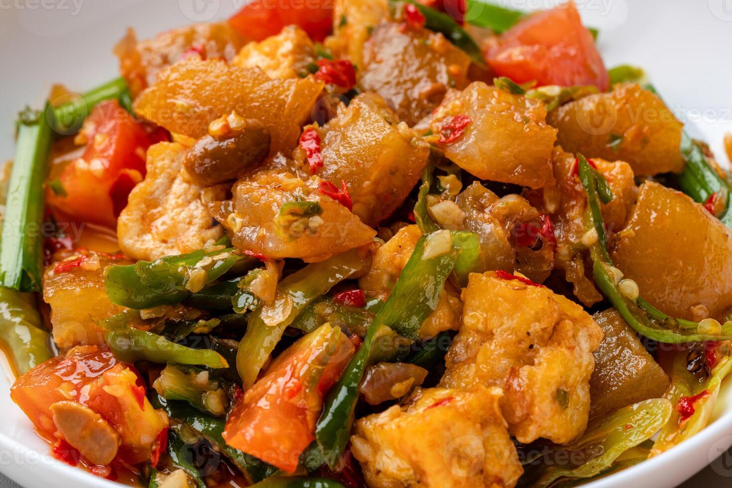Kikil or cow skin with spicy flavors is minang cuisine of West Sumatra, Indonesia. Kikil Cooked using Indonesian herbs, such as red chilies, shallots, garlic, tomatoes, etc. photo
