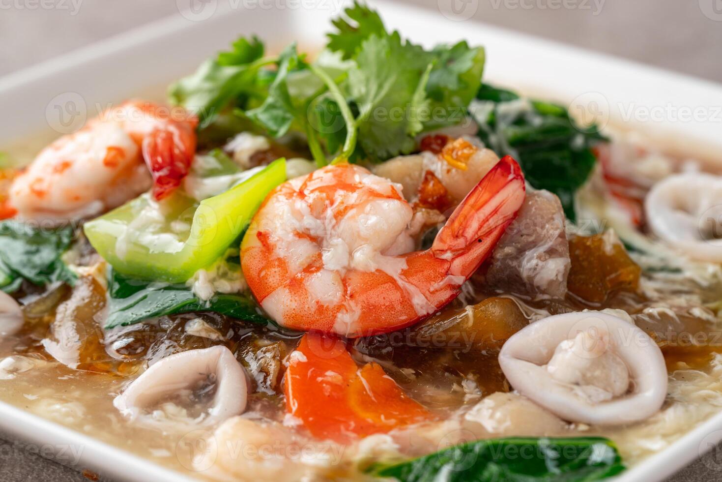 kwetiau siram is Chinese cuisine which is popular in Indonesia, cooked by frying added with complementary vegetables and chicken, seafood or beef meat and thick soup. photo