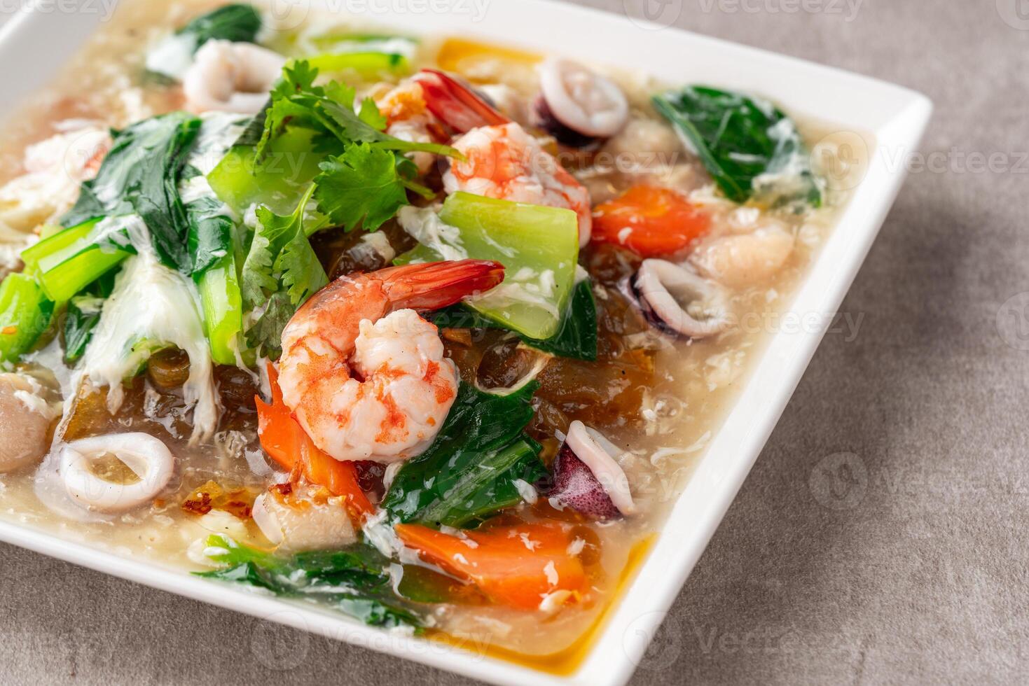kwetiau siram is Chinese cuisine which is popular in Indonesia, cooked by frying added with complementary vegetables and chicken, seafood or beef meat and thick soup. photo