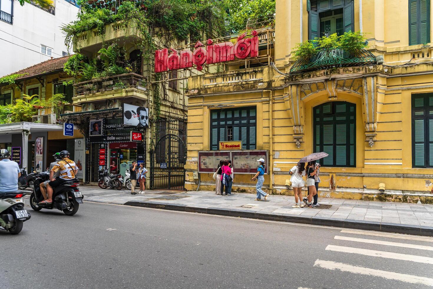 Hanoi, Vietnam - 26 June 2024 Hanoimoi newspaper check-in point near by Hoan Kiem lake. People have exercise in the morning on Ho Guom lake photo