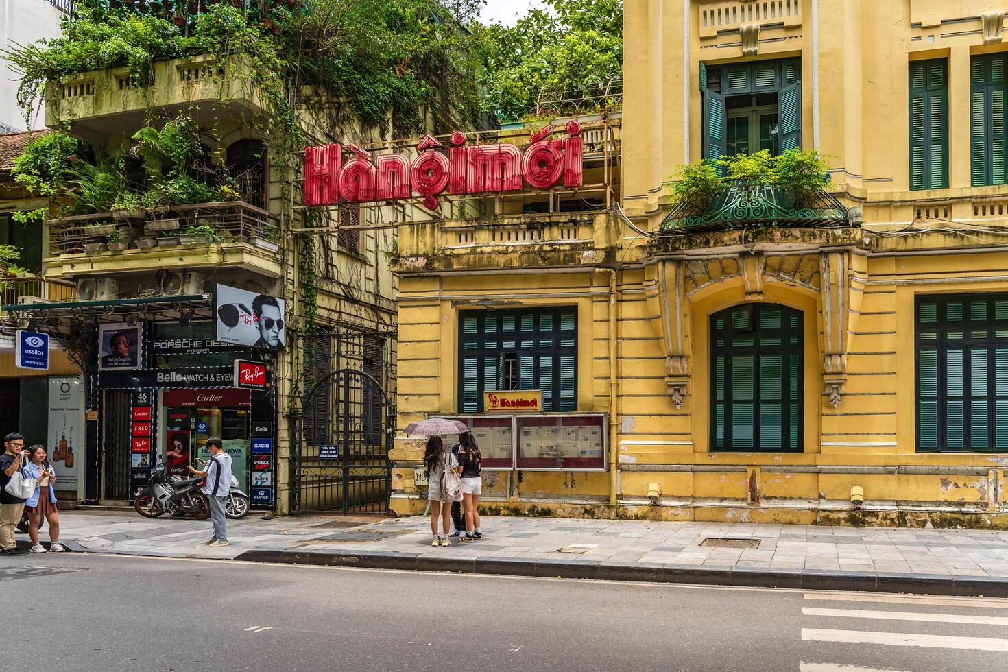 Hanoi, Vietnam - 26 June 2024 Hanoimoi newspaper check-in point near by Hoan Kiem lake. People have exercise in the morning on Ho Guom lake photo