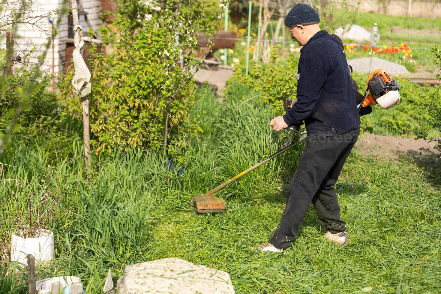 man with lawn mower, a man mows the grass photo