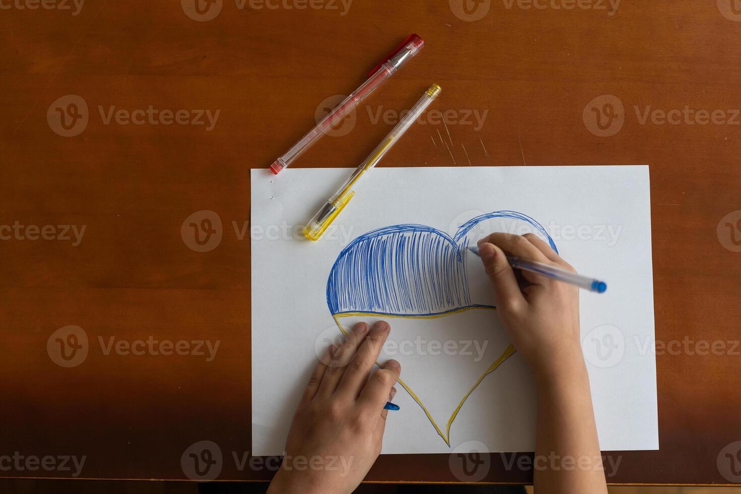 Close-up of childs hands drawing a heart photo