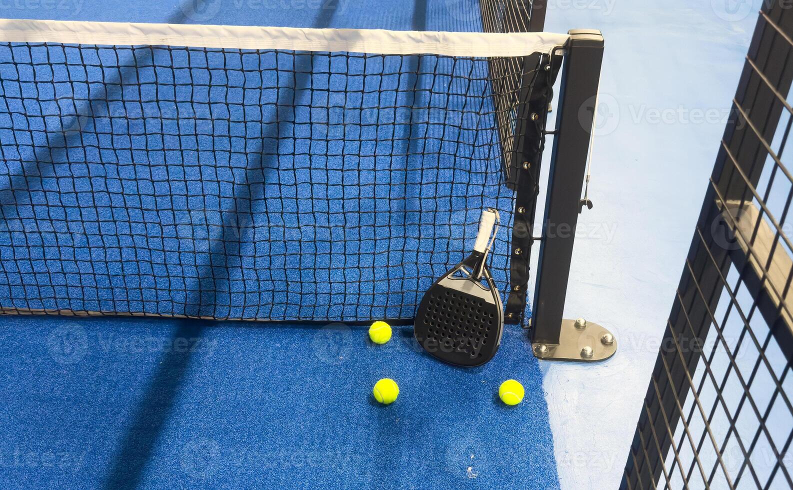 padel racket on a padel blue court with a ball photo