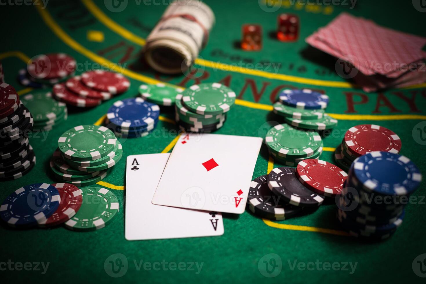 A closeup cards and different chips spread on a poker table photo