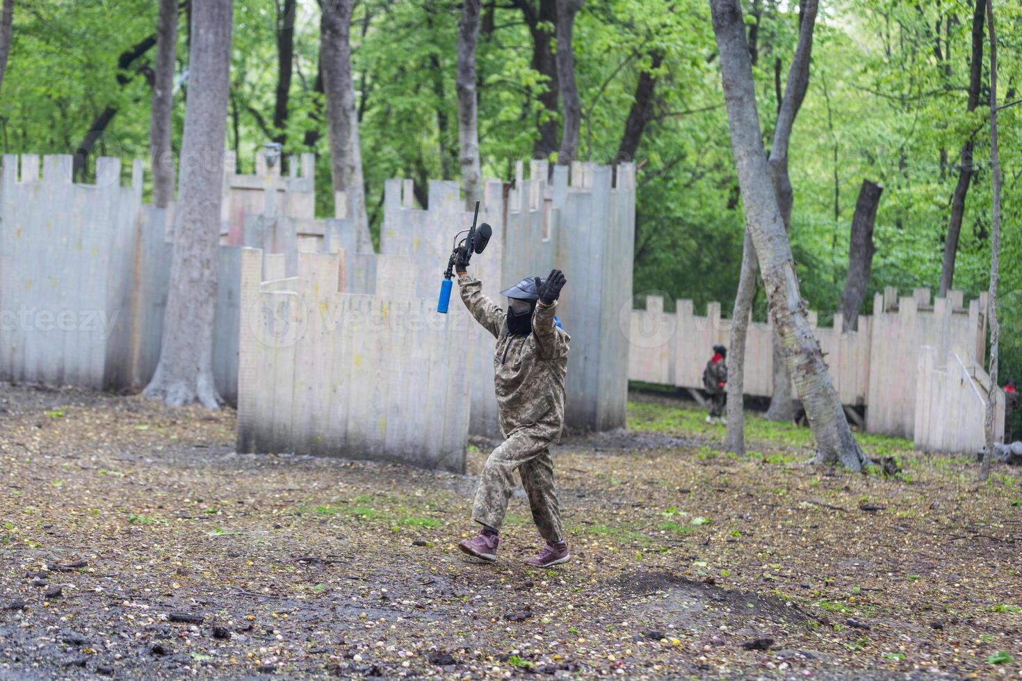 Warriors in camouflage and masks playing paintball photo