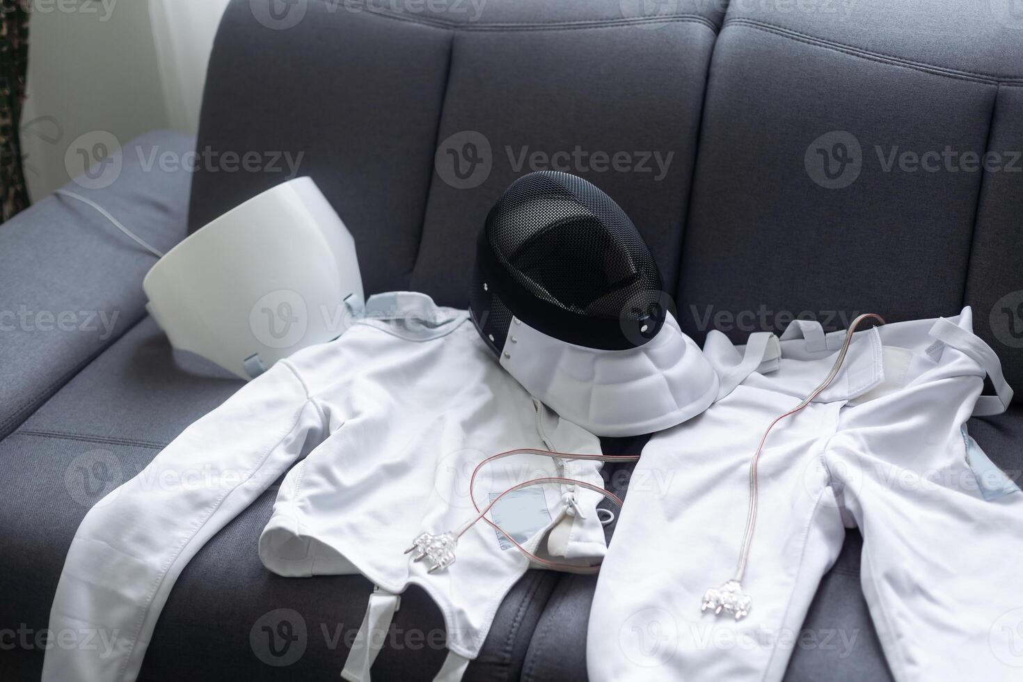 fencing mask and fencing suit on the couch photo
