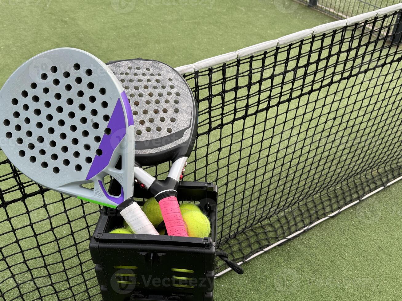 Background of padel racket and ball on artificial grass floor in outdoor court. Top view. photo