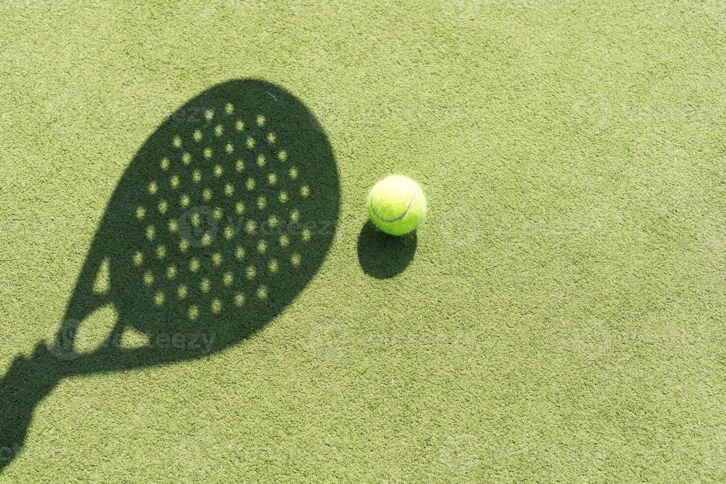 Paddle tennis racket shadow on balls. photo