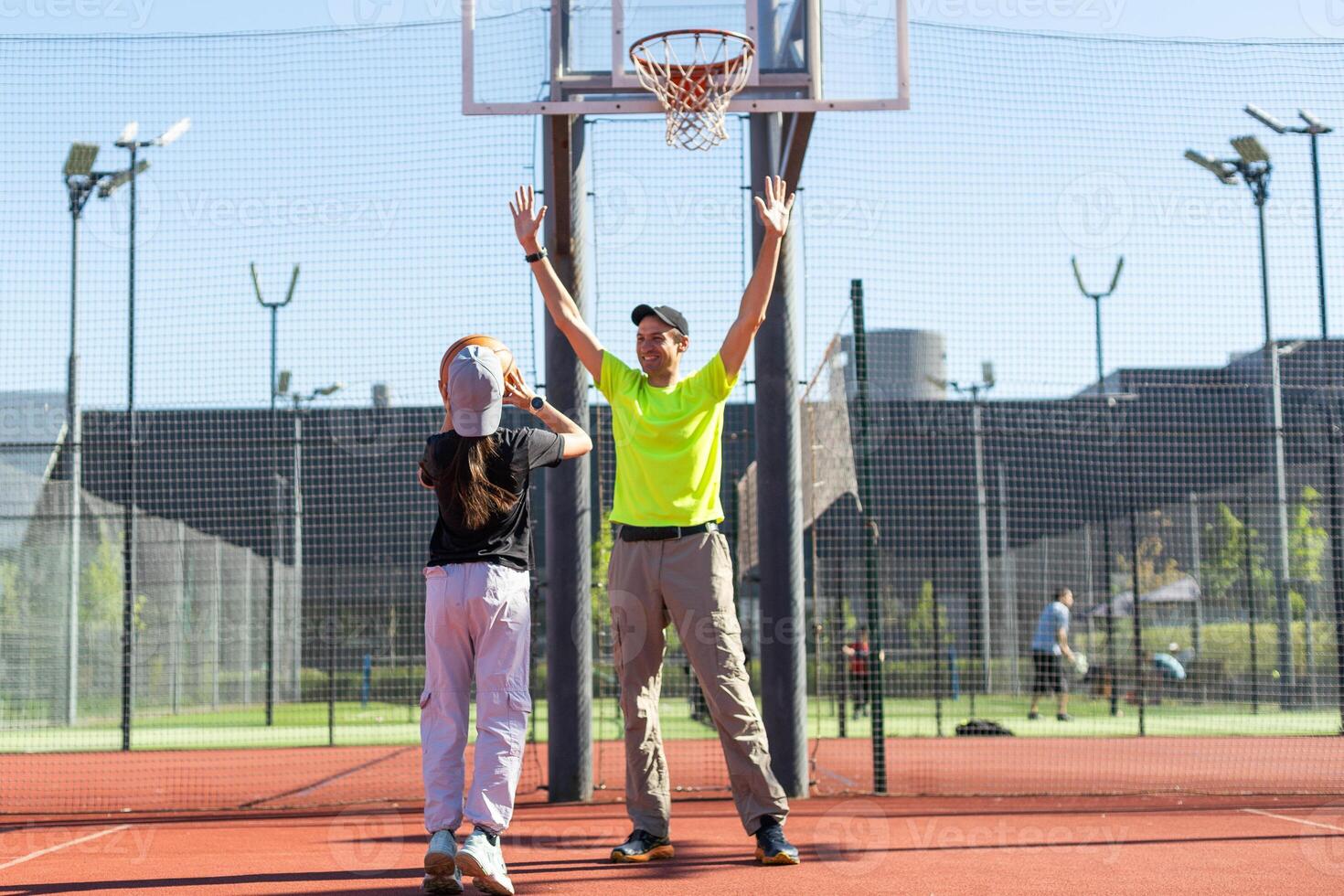 father and daughter playing basketball together on playground photo