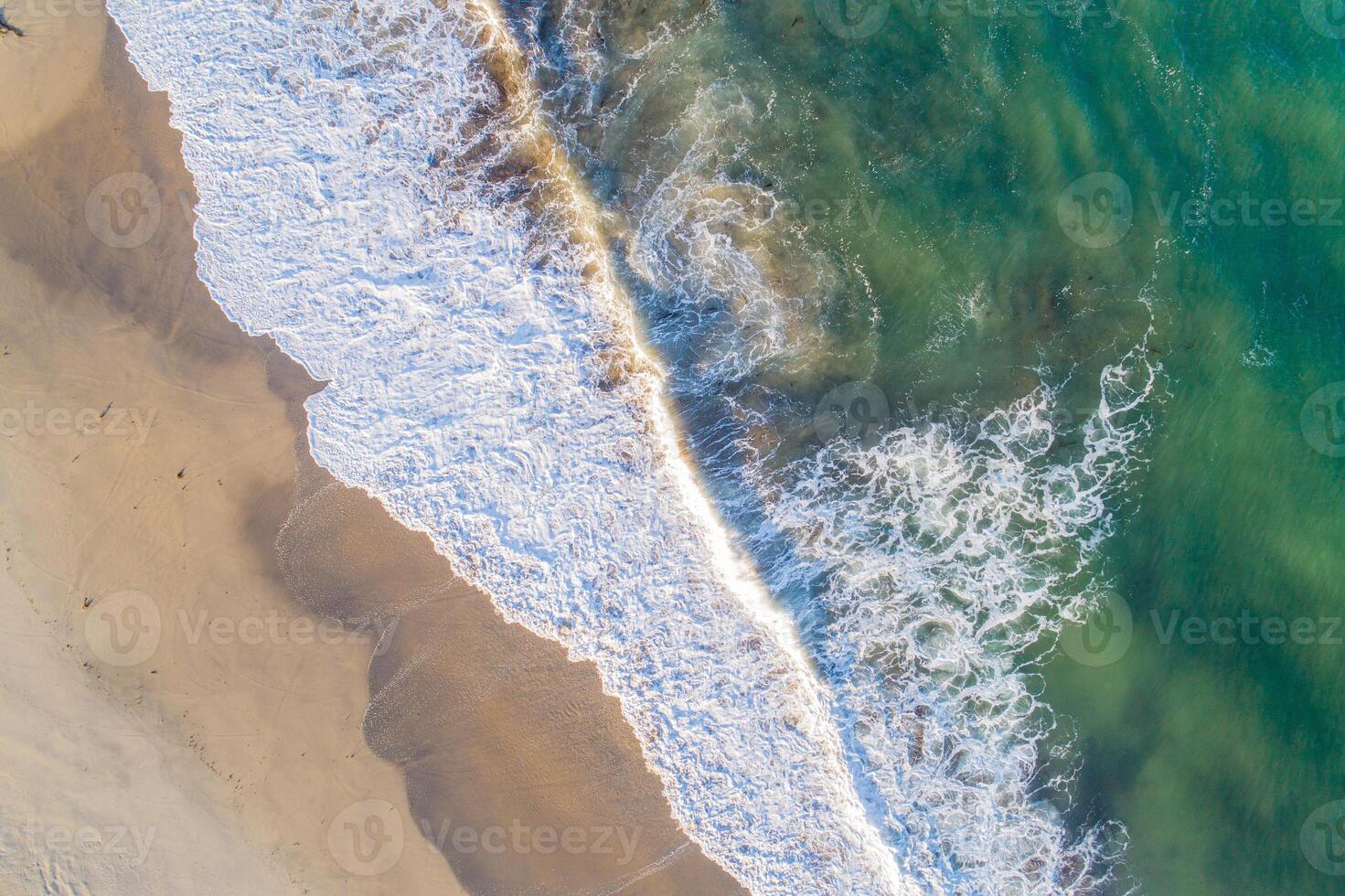 shore of a beach at sunrise, overhead view with drone photo