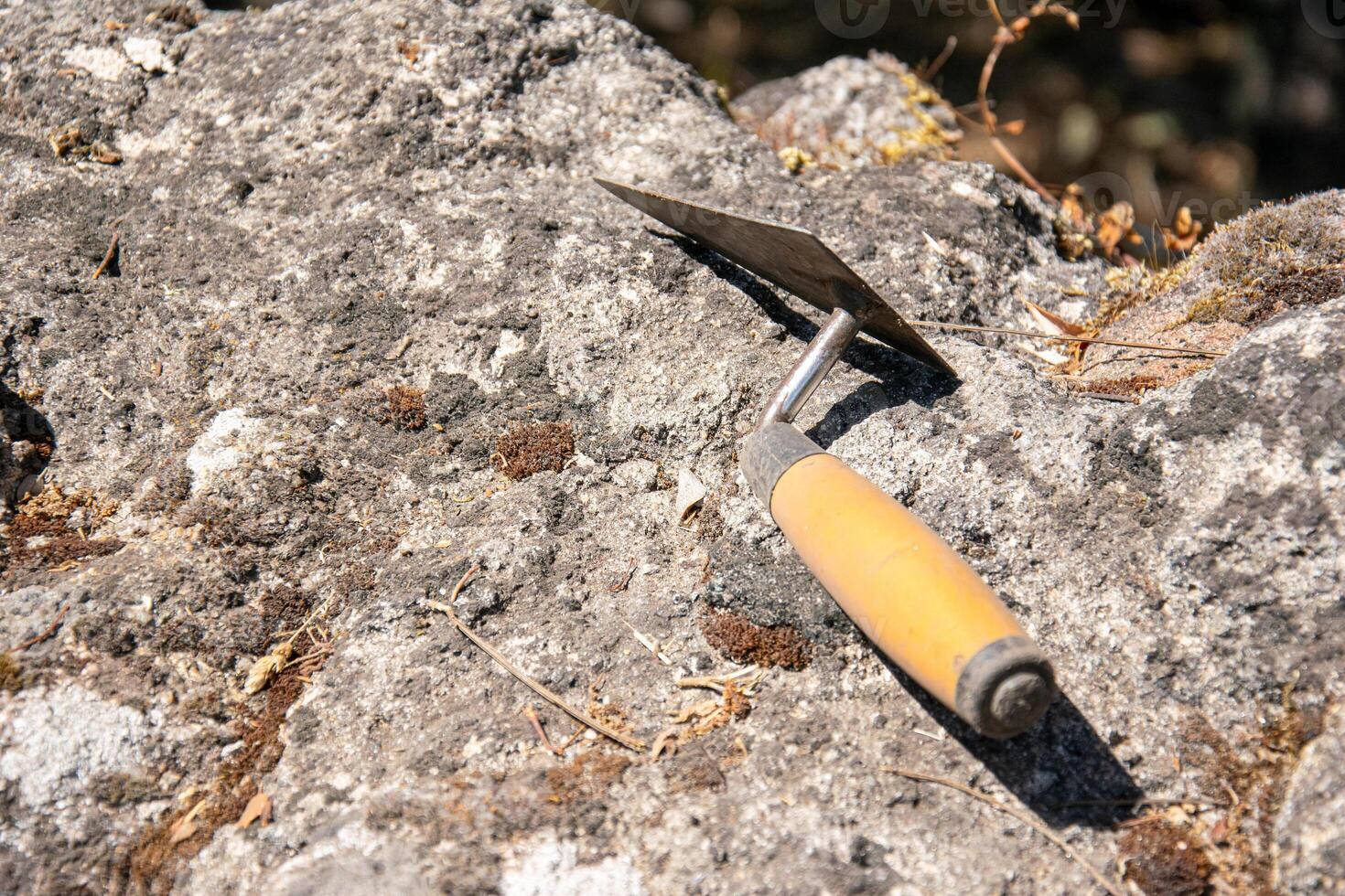 view of a trowel on a rock in an archaeological dig, archeology concept photo