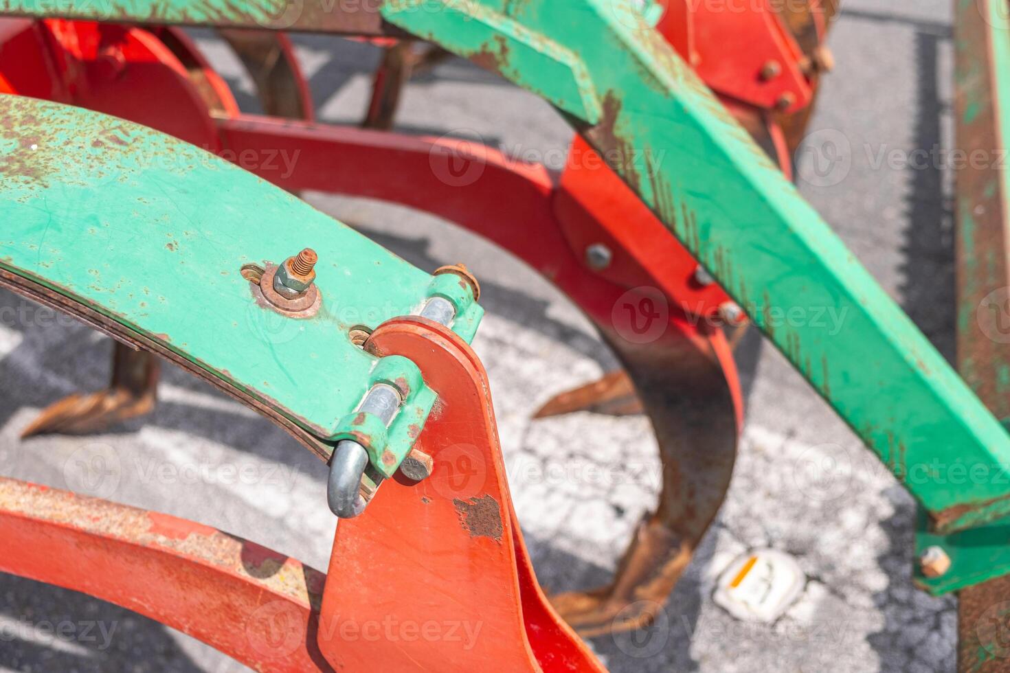 close up view of a red and green plow with signs of rusting photo