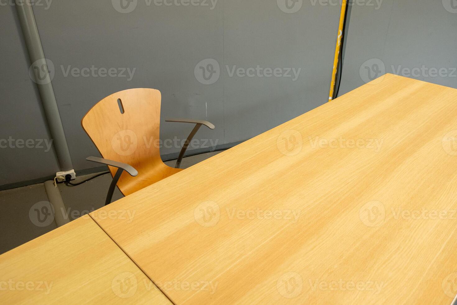an empty light wood chair and table in a classromm photo