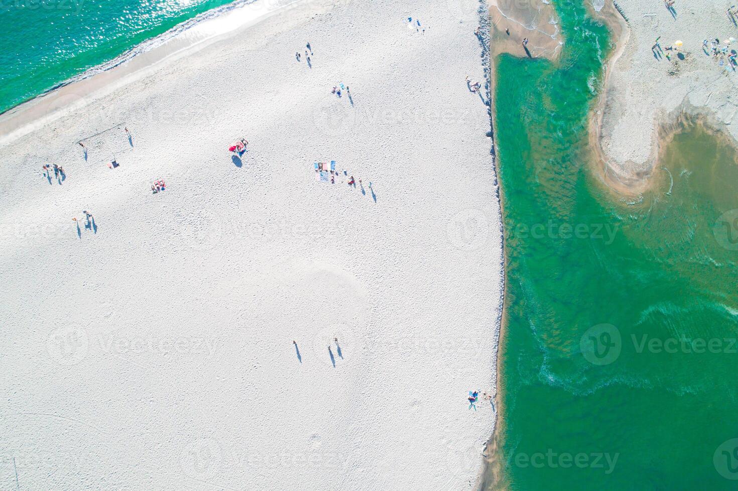 Aerial drone overhead view of people enjoying the summer at sand beach ,waves breaking against the coastline photo