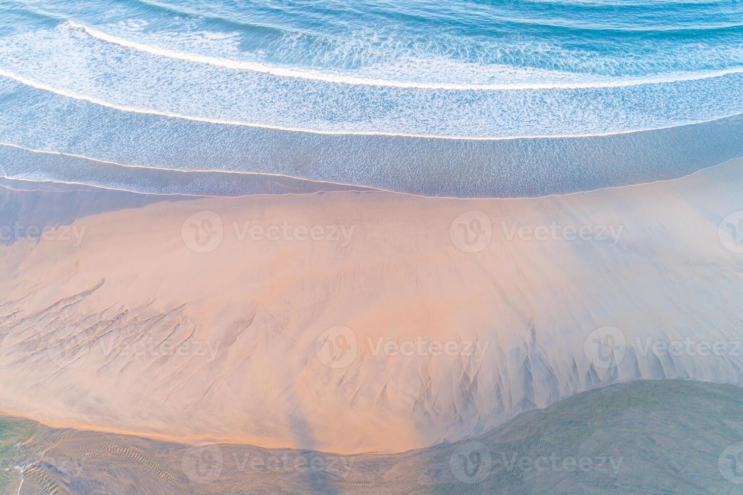 shore of a beach at sunrise, aerial top view with drone photo