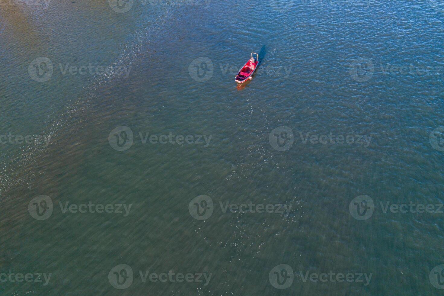 drone aerial view of a red ship in a calm sea photo