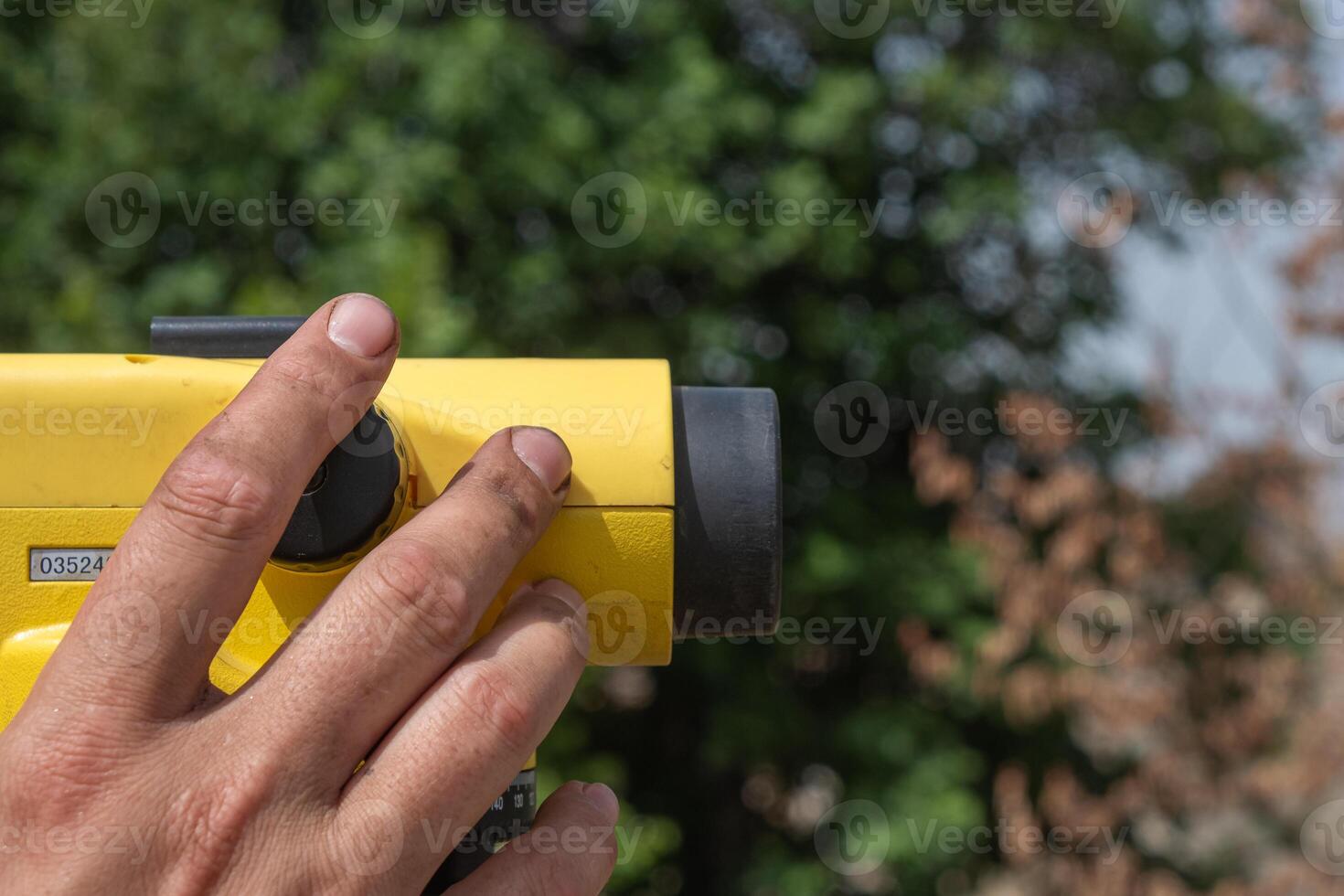 hand of a man using a theodolite, surveyor equipment tacheometer. Topography works photo
