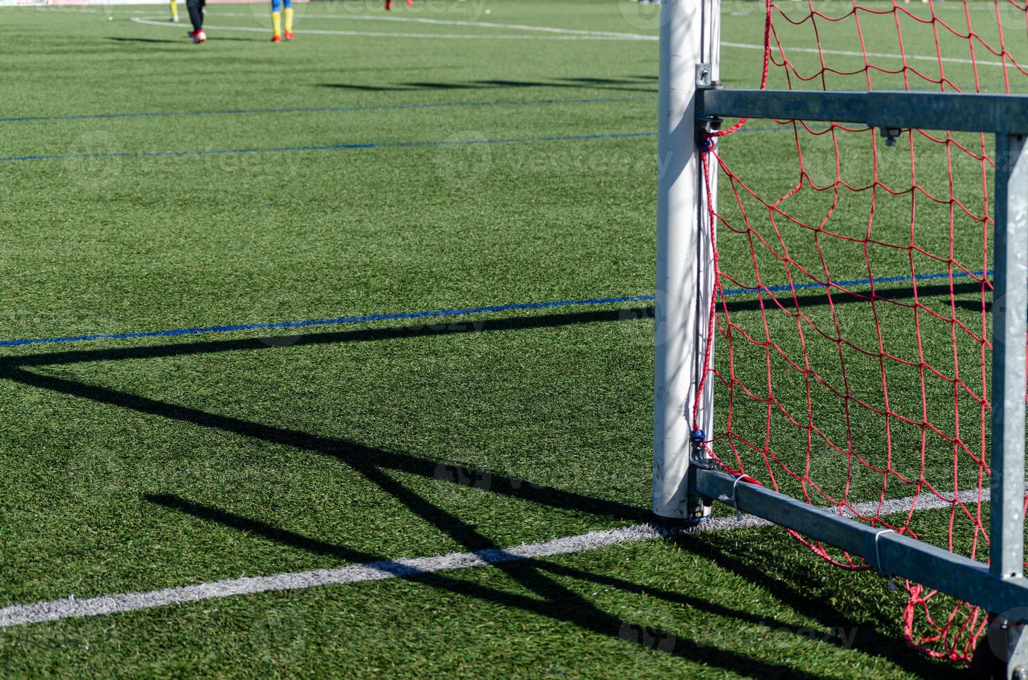 View of the surface and the goal of a soccer field during an amateur game. photo