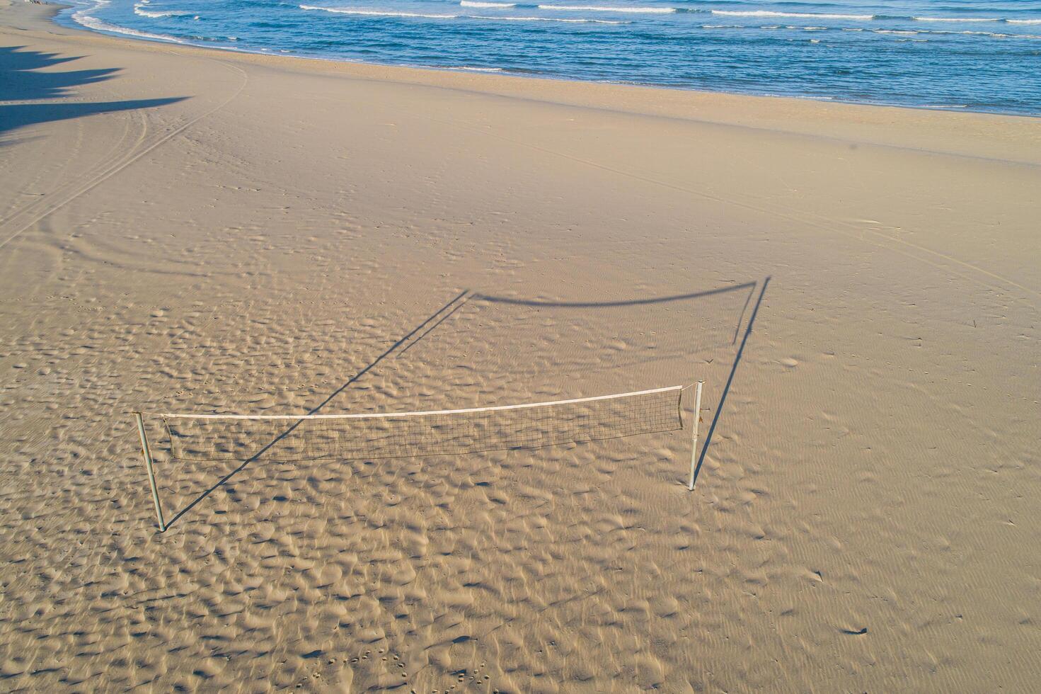 Aerial drone view of a beach volleyball net on a beach at sunset photo