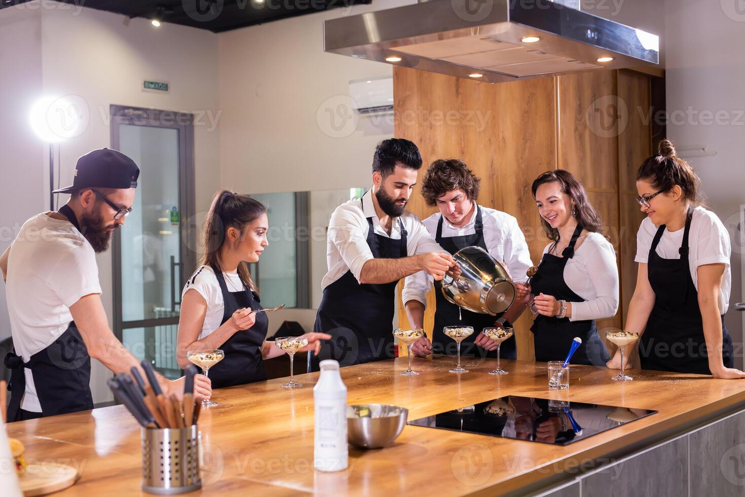 Chef teaching trainees how to make ice cream. Cooking tasty ice cream dessert made from chocolate and vanilla in glass bowl photo