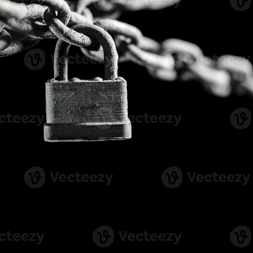Worn rusted chain and pad lock on black background. Conceptual strength, protection, or security system. photo