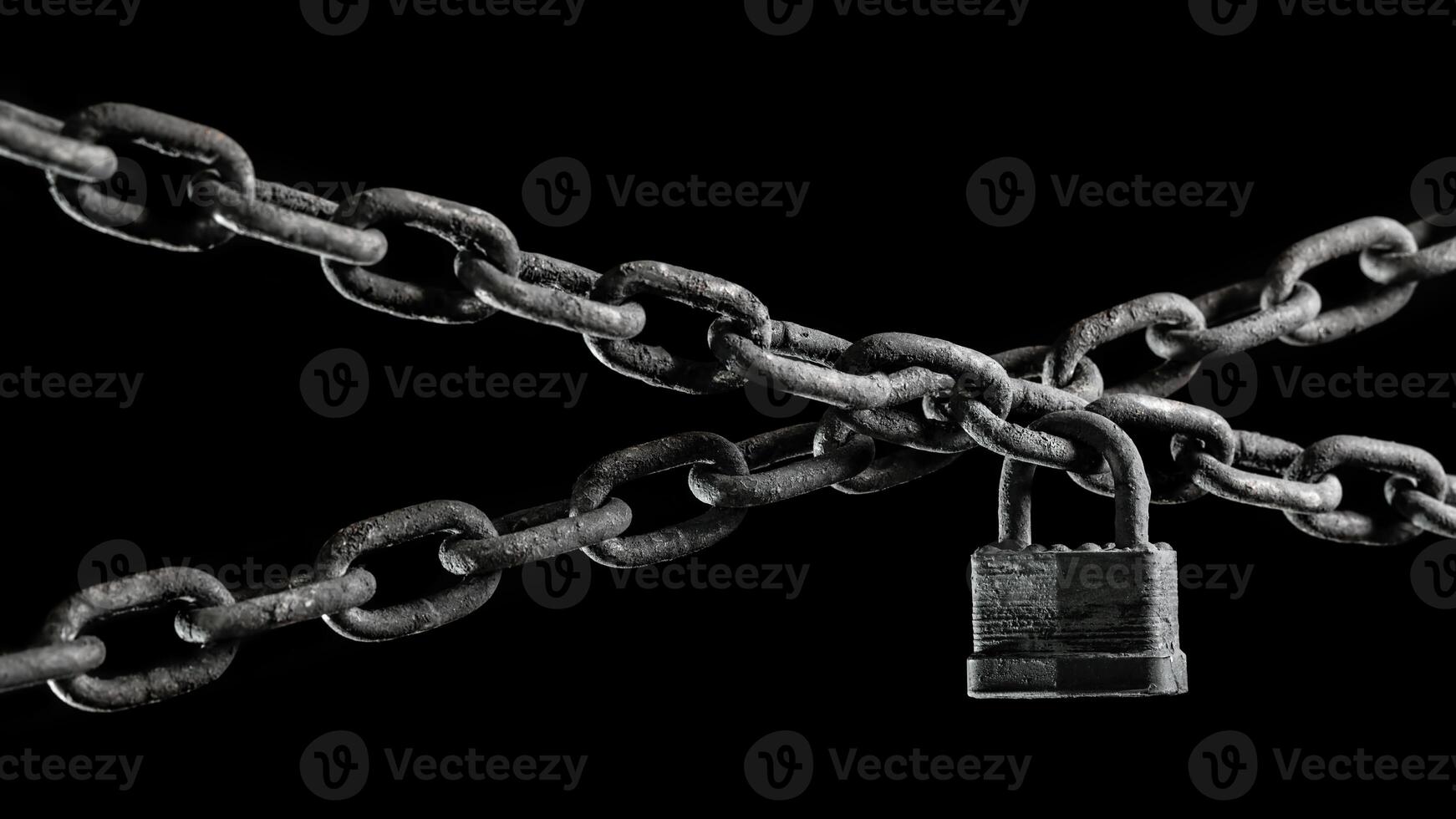 Worn rusted chain and pad lock on black background. Conceptual strength, protection, or security system. photo