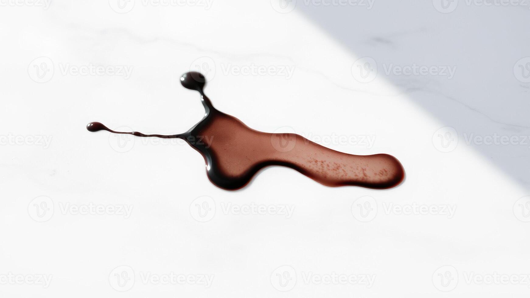 A Single Drop of Dark Liquid on a White Surface photo