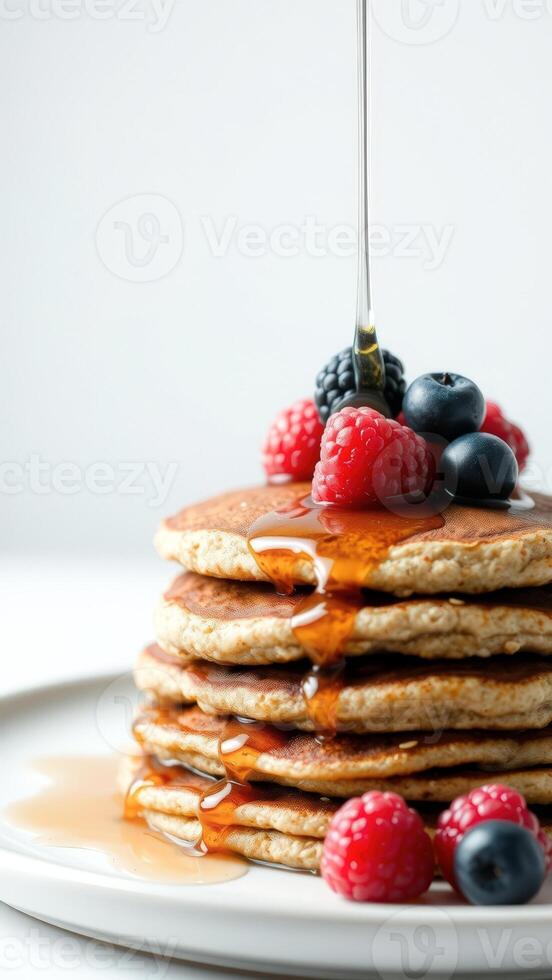 Stack of pancakes with maple syrup and berries photo