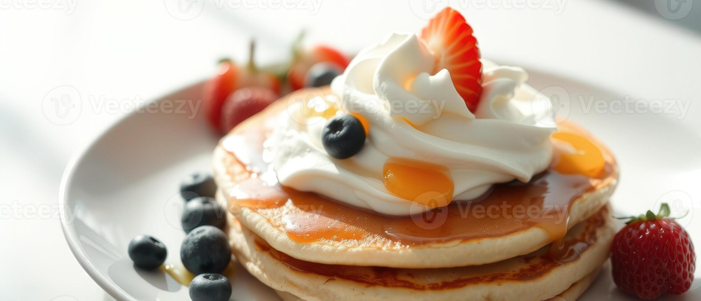 Close up of pancakes with whipped cream and berries on white plate photo