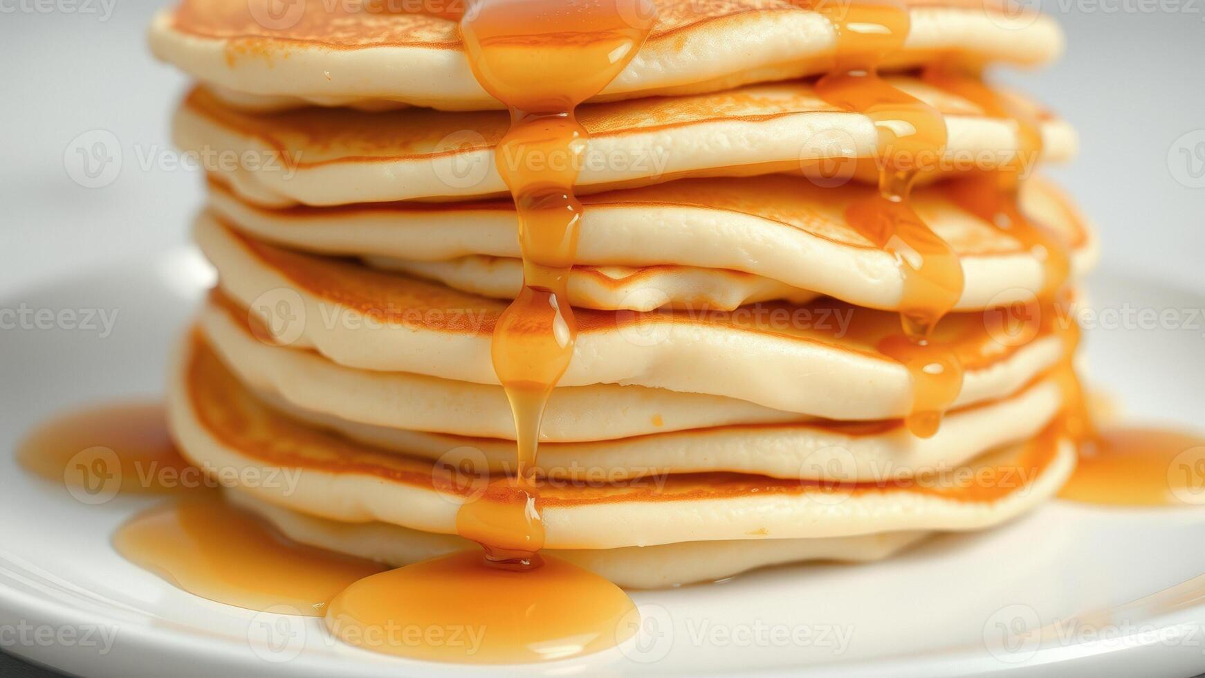 Closeup of a stack of golden pancakes drizzled with syrup photo