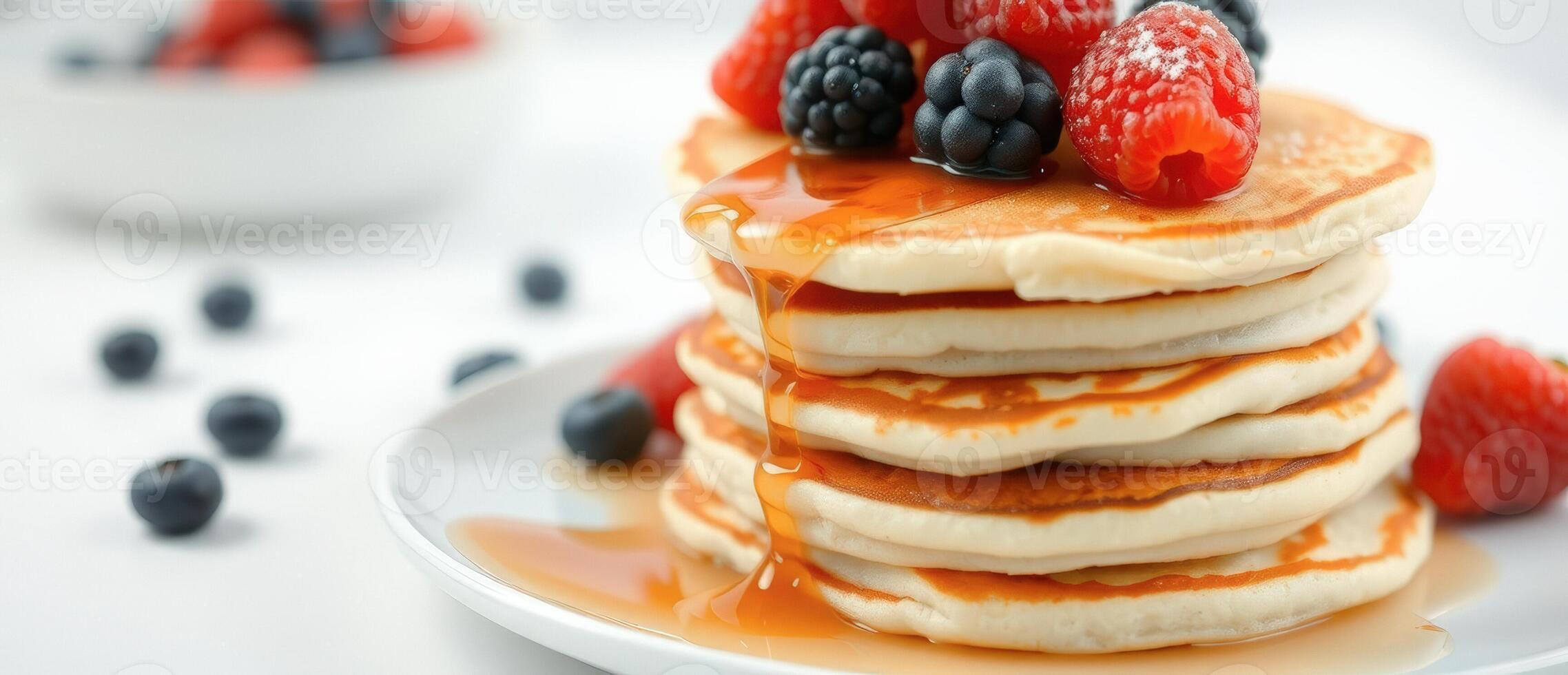 Close up of a stack of pancakes with berries and syrup photo