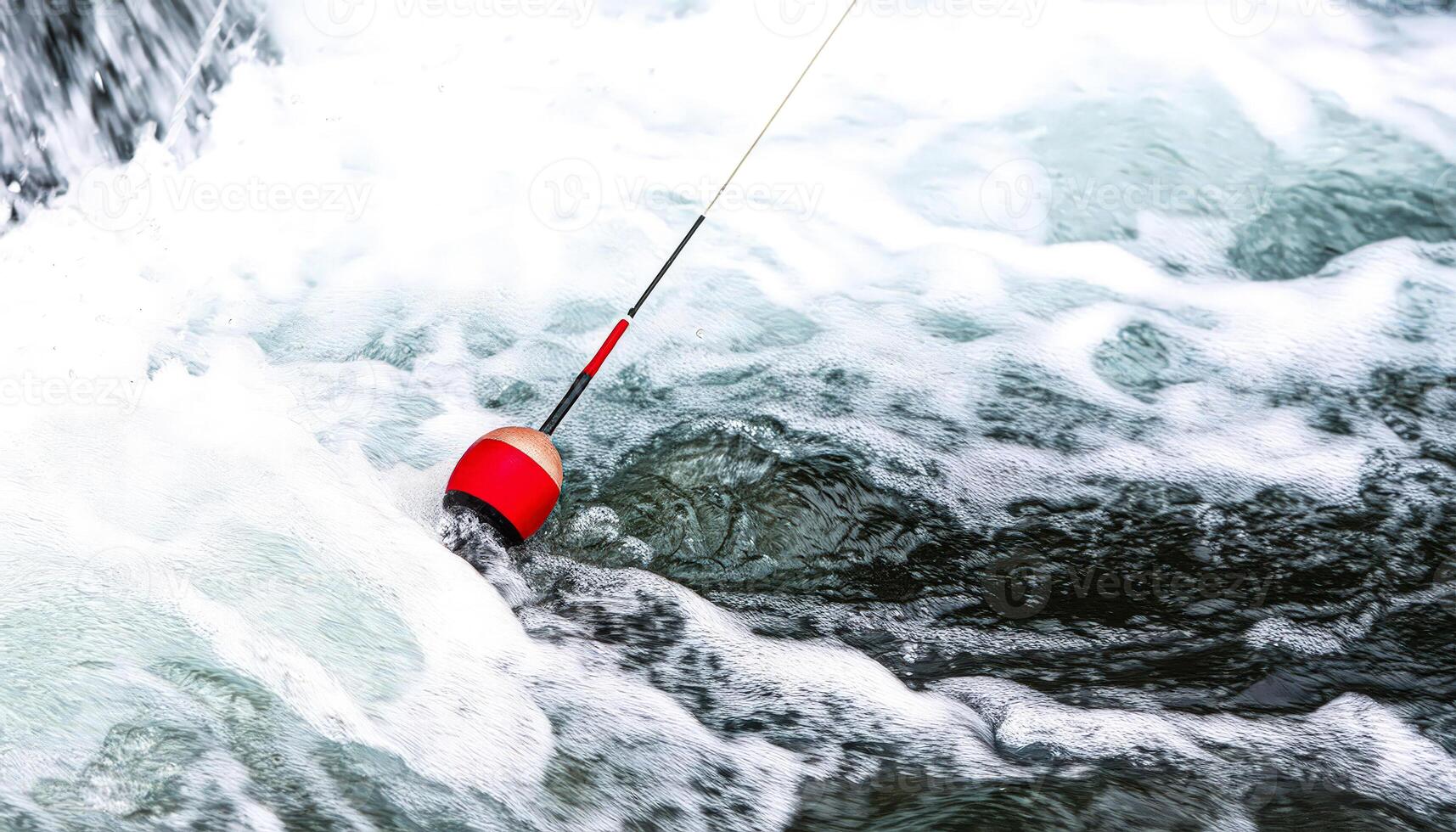 Red bobber floats in a rushing river photo