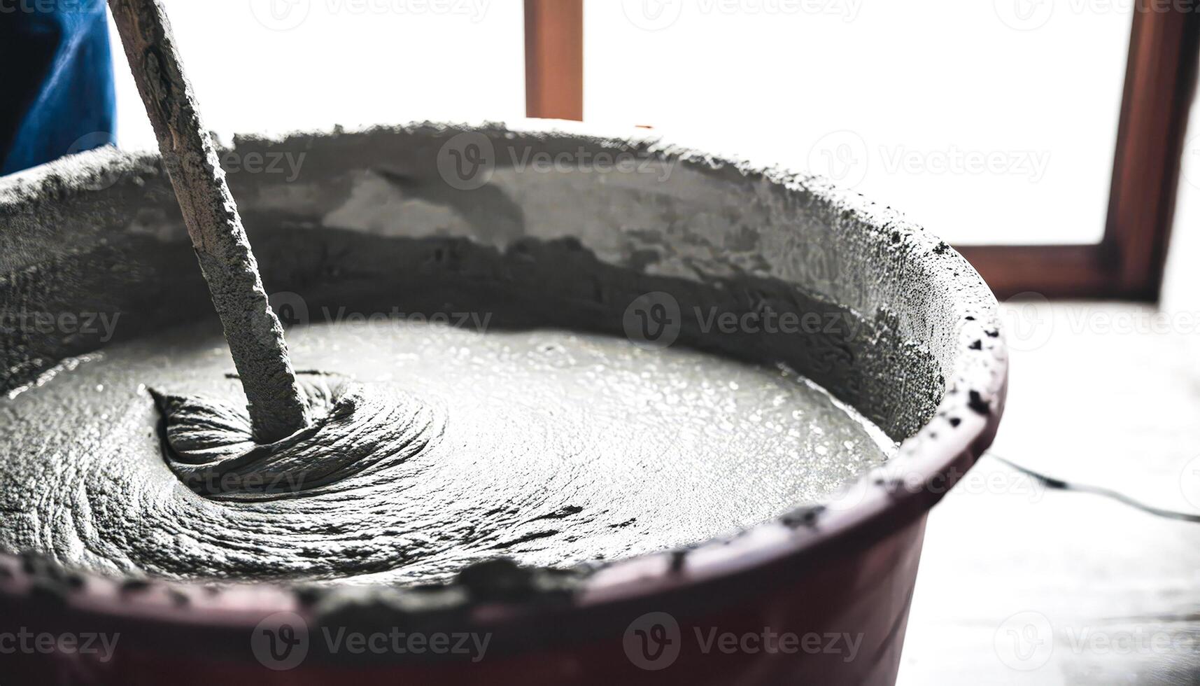Close-up of a worker mixing concrete in a bucket photo